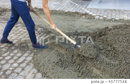 the worker leveling the foundation with a shovel the worker leveling the foundation with a shovel 43777538