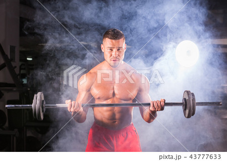 Handsome power athletic man with barbell. Strong bodybuilder with six pack, perfect abs, shoulders Handsome power athletic man with barbell. Strong bodybuilder with six pack, perfect abs, shoulders 43777633