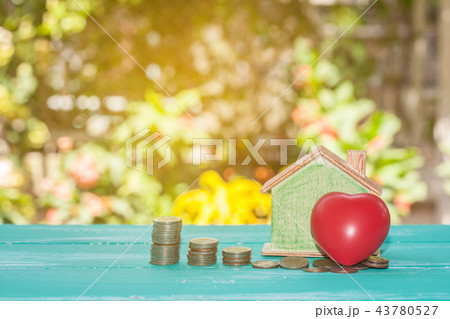 House model with red heart and stack of coins House model with red heart and stack of coins 43780527