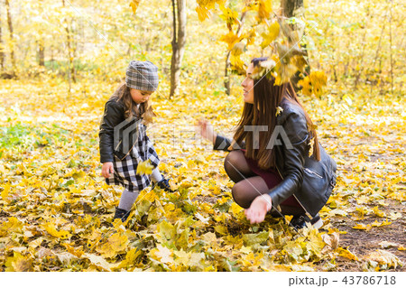 Happy family concept - mother and child little daughter playing in autumn nature 43786718