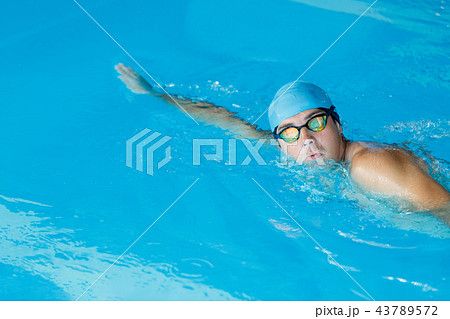 Portrait of sportive man in blue cap floating in pool Portrait of sportive man in blue cap floating in pool 43789572