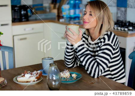 Young girl with cup and cake at kitchen  43789859
