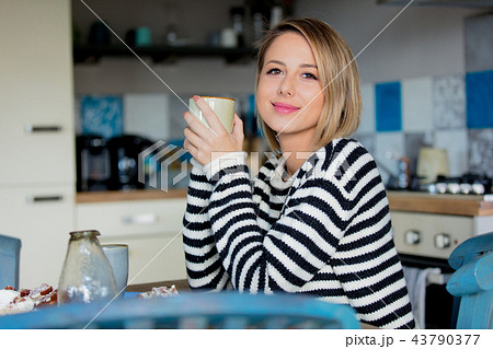 Young girl with cup and cake at kitchen  43790377