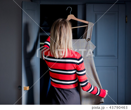 Young girl choose a dress at home near wardrobe 43790463
