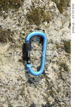 Carabiner on rocky background. Carabiner on rocky background. 43791400