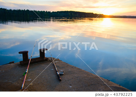fishing rods lie on the dock next to the river 43792225