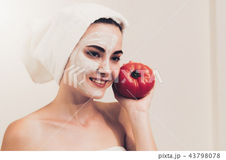 Woman get facial mask with tomato cream extract. 43798078