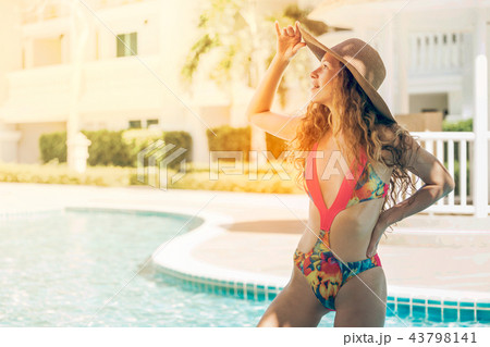 Happy young woman in swimsuit at swimming pool. 43798141