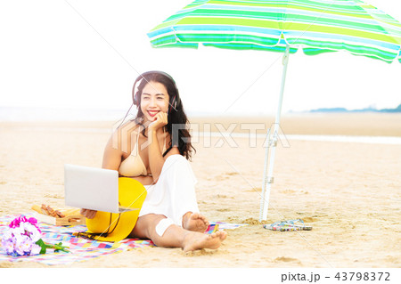 Plus size young woman sitting on the beach. 43798372