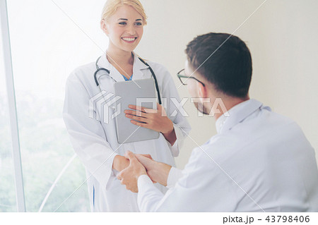 Doctor at hospital shakes hand with another doctor Doctor at hospital shakes hand with another doctor 43798406