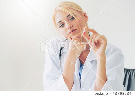 Young woman doctor holding a medicine pill in hand 43798534