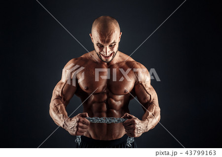 Portrait of aggressive bodybuilder trying to tear the metal chain Portrait of aggressive bodybuilder trying to tear the metal chain 43799163