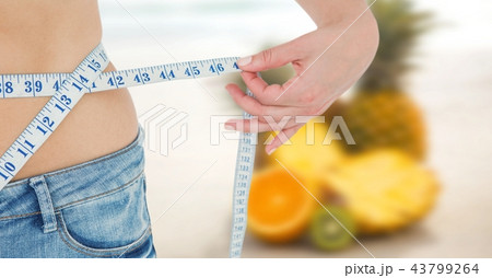 Composite image of midsection of woman measuring waist 43799264
