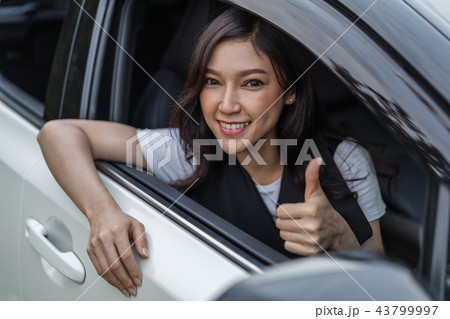 woman giving thumb up inside her car woman giving thumb up inside her car 43799997