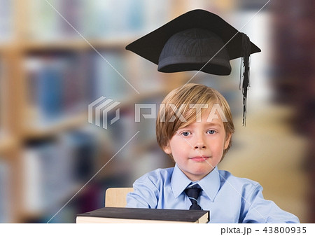 School boy in education library with graduation hat School boy in education library with graduation hat 43800935