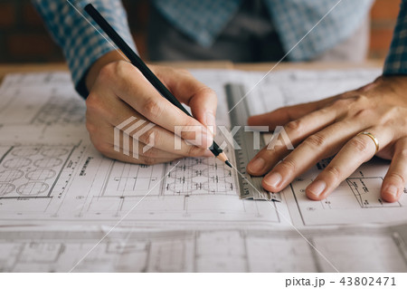 Interior designer or architect reviewing blueprint 43802471