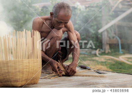 Ole man are weaving basket. 43803698