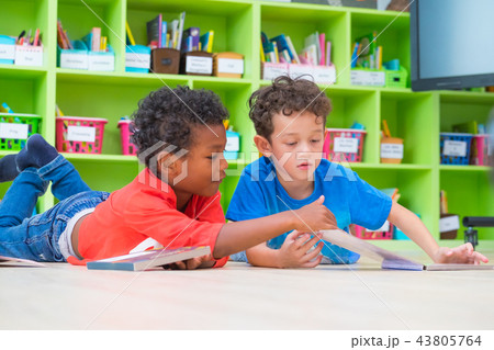 Two boy kid lay down on floor and reading tale Two boy kid lay down on floor and reading tale 43805764