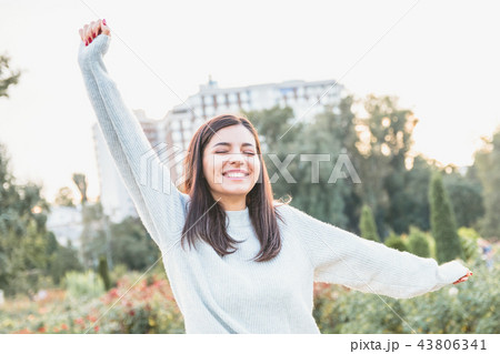Young attractive woman in light colored sweater welcoming and trying to hug the viewer 43806341