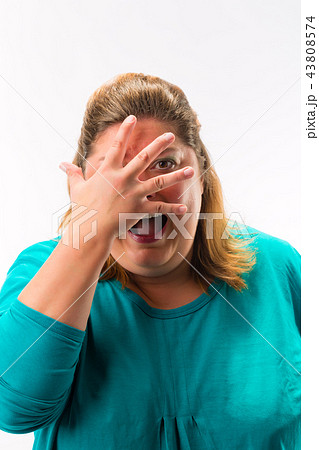 Scared woman peeking from fingers over the face 43808574
