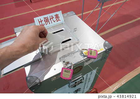 比例代表選挙日に投票所の投票記載台で候補者を記入し投票箱に投票用紙を投函する有権者 比例代表選挙日に投票所の投票記載台で候補者を記入し投票箱に投票用紙を投函する有権者 43814921