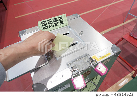 国民審査投票日に投票所の投票記載台で候補者を記入し投票箱に投票用紙を投函する有権者 国民審査投票日に投票所の投票記載台で候補者を記入し投票箱に投票用紙を投函する有権者 43814922