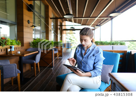 Beautiful girl working with tablet at restaurant  . 43815308