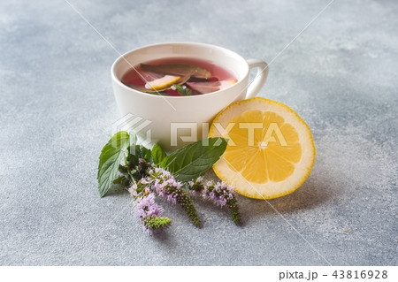 Cup of tea, mint and lemon on grey table Cup of tea, mint and lemon on grey table 43816928