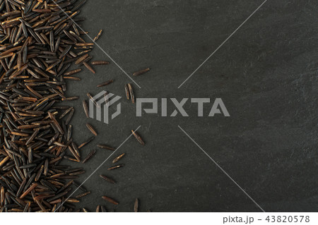 Raw Black Wild Rice on Dark Stone Background 43820578