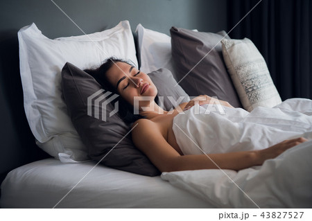 hotel, travel and happiness concept - beautiful woman sleeping in bed hotel, travel and happiness concept - beautiful woman sleeping in bed 43827527