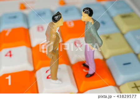 電卓の上で向かい合う男性 電卓の上で向かい合う男性 43829577