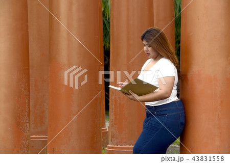 Pretty Asian fat women pose and writing on a book. Pretty Asian fat women pose and writing on a book. 43831558