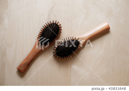 Black hair with wood comb on a wooden table. 43831648
