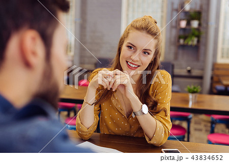 Beautiful young girl smiling and looking attentively at the young barman 43834652