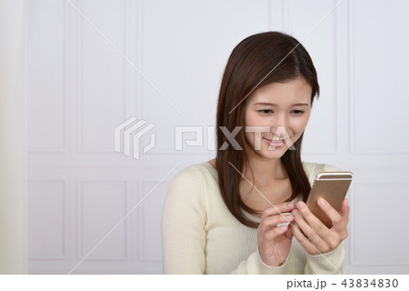スマートフォンを持つ笑顔の女性 43834830
