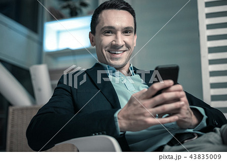 Pleasant business man texting a message on his phone Pleasant business man texting a message on his phone 43835009
