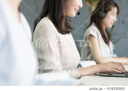 インカムで話すコールセンターの若い女性 インカムで話すコールセンターの若い女性 43838960