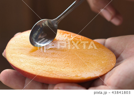 瑞々しいマンゴーにスプーンを入れる イメージ 瑞々しいマンゴーにスプーンを入れる イメージ 43841803