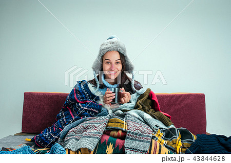 The young woman with Flue Sitting on Sofa at Home. Healthcare Concepts. The young woman with Flue Sitting on Sofa at Home. Healthcare Concepts. 43844628