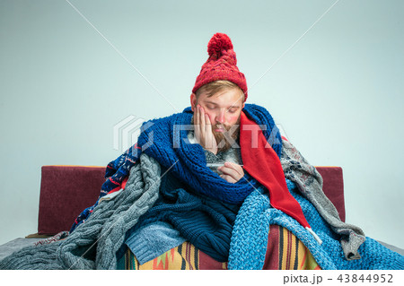 Bearded Man with Flue Sitting on Sofa at Home. Healthcare Concepts. 43844952