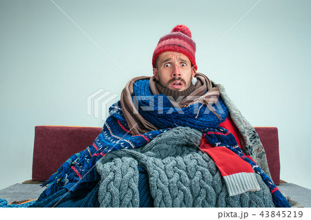 Bearded Man with Flue Sitting on Sofa at Home. Healthcare Concepts. Bearded Man with Flue Sitting on Sofa at Home. Healthcare Concepts. 43845219