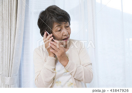 不審な電話に出るシニア女性　オレオレ詐欺 43847926