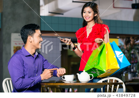 Happy young man waiting for his beautiful girlfriend after shopping 43849728