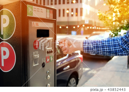 man is paying his parking at parking pay terminal 43852443