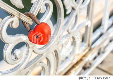 Red heart padlock locked on fence. Lock in shape of heart as symbol of eternal love Red heart padlock locked on fence. Lock in shape of heart as symbol of eternal love 43853567