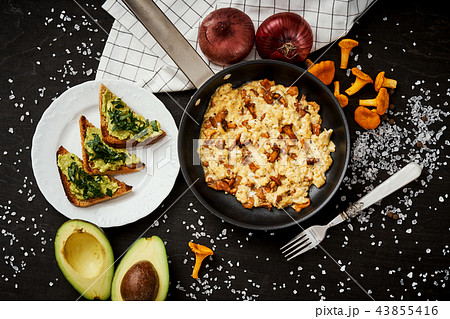 scrambled eggs with chanterelles straight from the forest in a pan and bread with avocado scrambled eggs with chanterelles straight from the forest in a pan and bread with avocado 43855416
