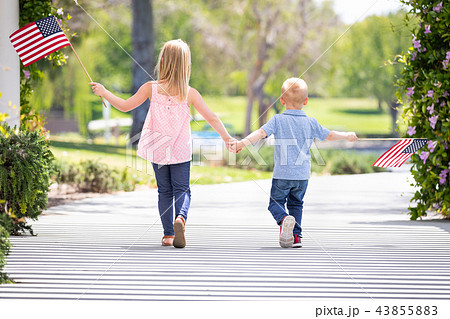 Sister and Brother Outdoors Waving American Flags 43855883