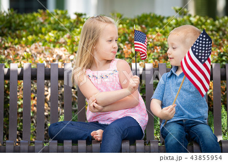 Sister and Brother Waving American Flags On Bench Sister and Brother Waving American Flags On Bench 43855954