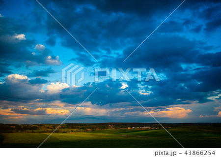 Dark blue clouds moving over green fields Dark blue clouds moving over green fields 43866254