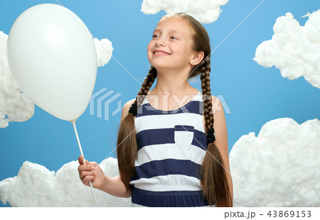 girl in striped dress on blue with cotton clouds girl in striped dress on blue with cotton clouds 43869153